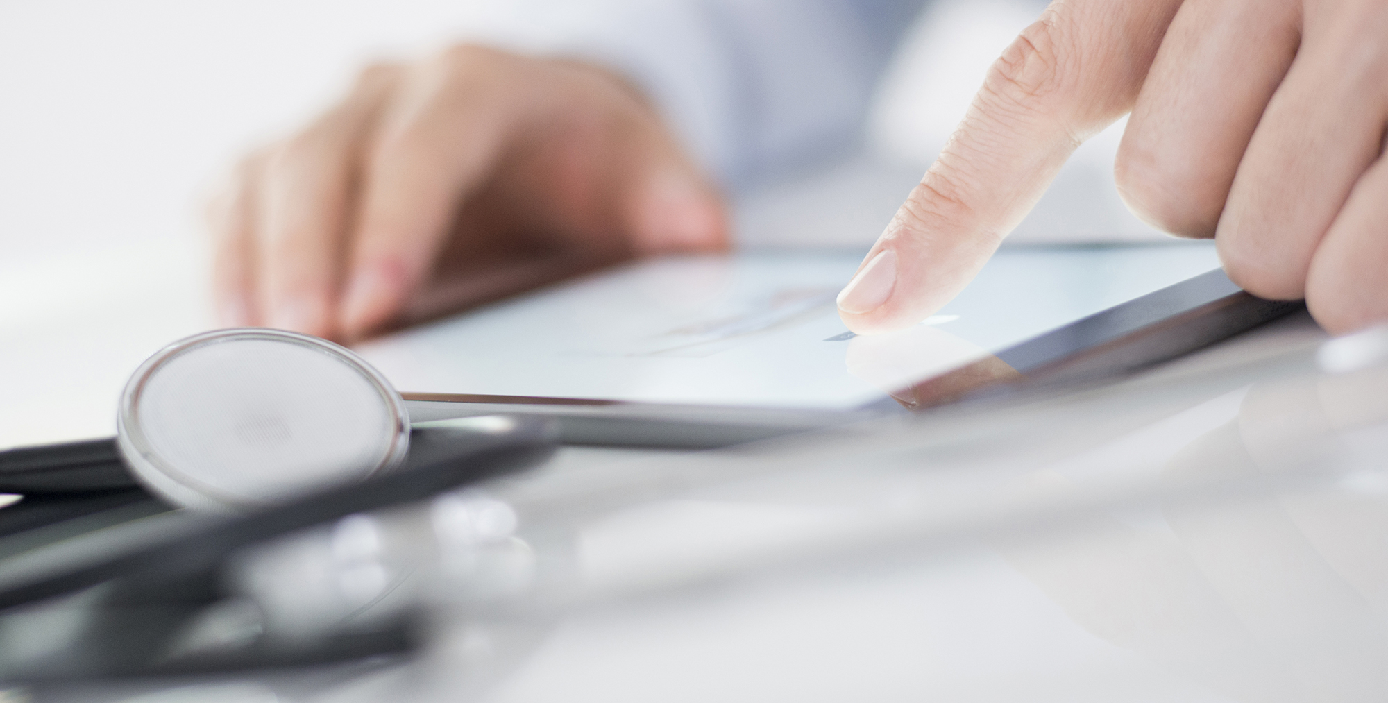 Close up image of hands on a chart or tablet.
