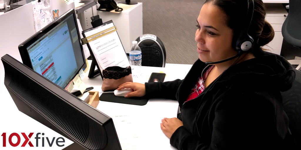 Woman on phone through headset at work station