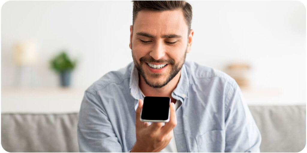 Man talking into a cell phone showing another way conversational AI works